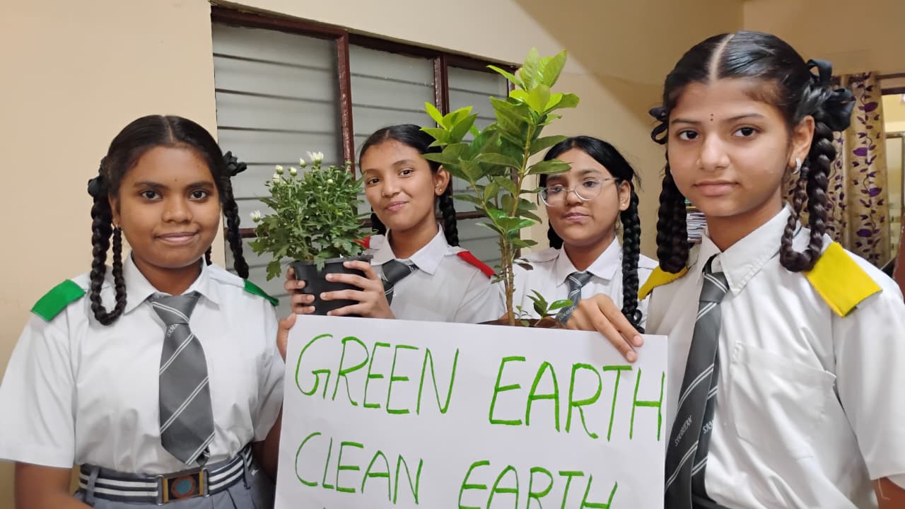Students holding a Green Earth Clean Earth poster